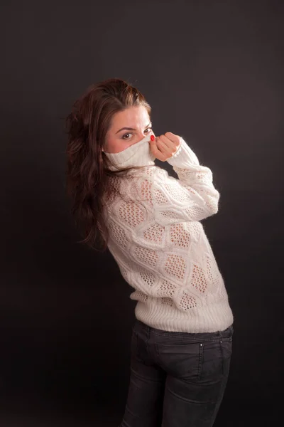 黒い背景をした白いジャンパーの少女のスタジオポートレート — ストック写真