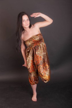 Parlak pantolonlu bir kızın stüdyo portresi.