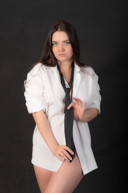 Beyaz gömlekli ve kravatlı şehvetli kızın stüdyo portresi.