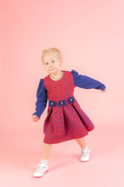 Pembe arka planda küçük bir kızın stüdyo portresi