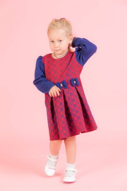 Pembe arka planda küçük bir kızın stüdyo portresi