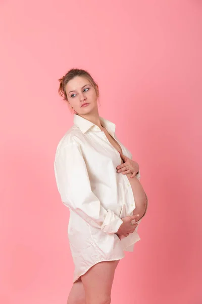 ピンクの背景の妊娠中の女性のスタジオ ポートレート — ストック写真