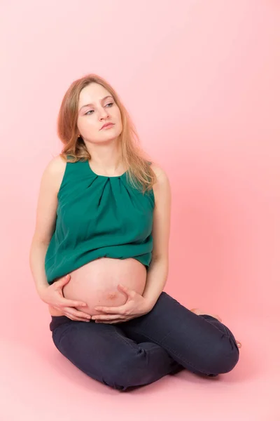 분홍색 배경에 임신한 여자의 스튜디오 초상화 — 스톡 사진