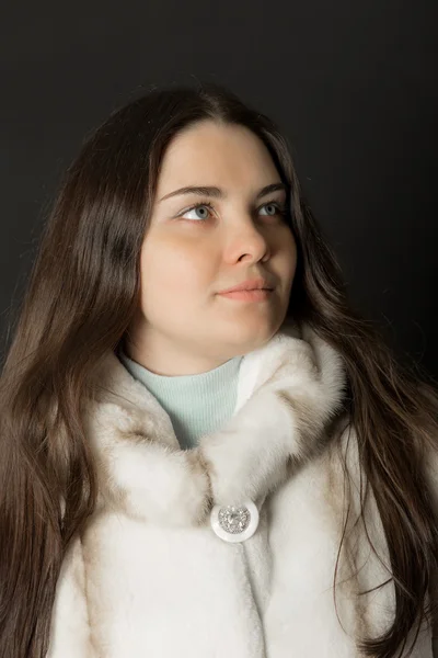 Meisje in een wit bont jas close-up — Stockfoto