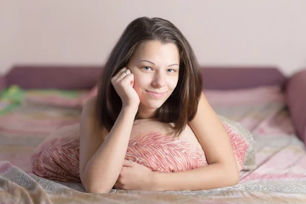 Meisje op een bed — Stockfoto
