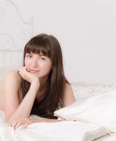 Meisje op een bed — Stockfoto