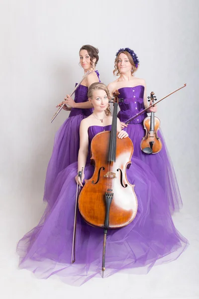 Trio musical em vestidos de noite — Fotografia de Stock