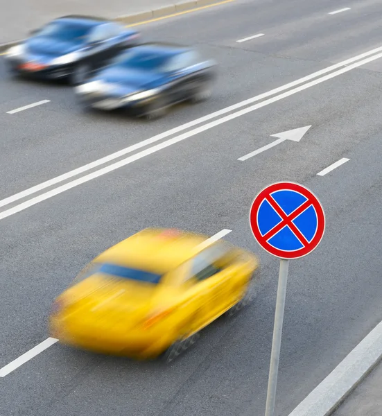 Señal de tráfico parada prohibida y un coche en movimiento —  Fotos de Stock