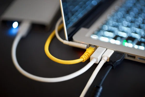 Laptop and wires from from various devices — Stock Photo, Image