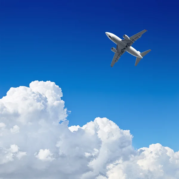 ढग सह निळा आकाशात उड्डाण करणारे विमान — स्टॉक फोटो, इमेज