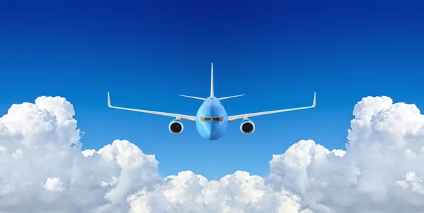 Bulutların arasında mavi gökyüzünde uçan yolcu uçak — Stok fotoğraf