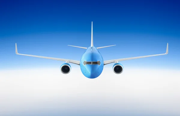Пасажирський літак летить у блакитному небі серед хмар — стокове фото