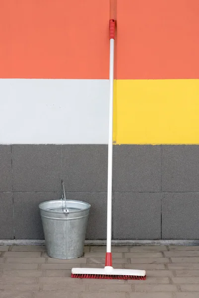 Mop and bucket against the wall on the pavement — Stock Photo, Image