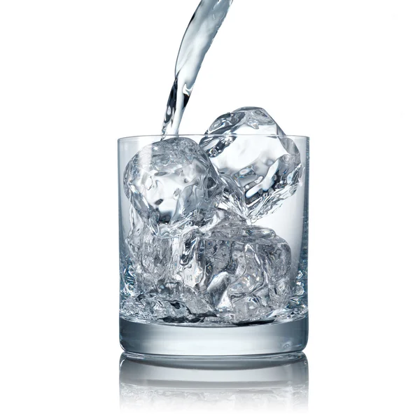 Nalévání vody do sklenice s ledem — Stock fotografie