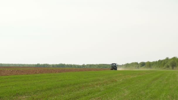 Trekker rijden in het veld — Stockvideo