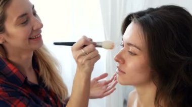 Makyaj sanatçısı tarafından makyaj yapan güzel bir kadın.