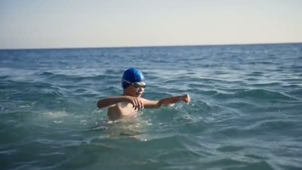 Child teen boy swims in the sea water. — Stock Video