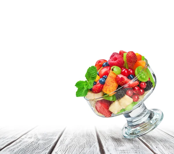 Salada de frutas frescas em tigela de vidro no fundo de madeira branca — Fotografia de Stock