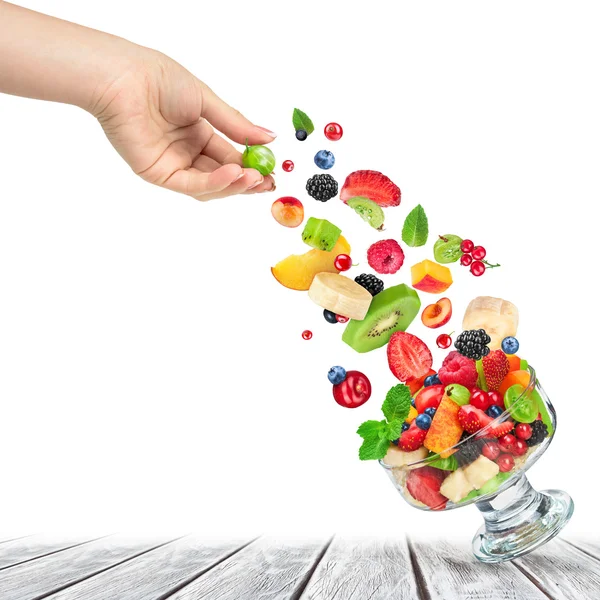 Salade de fruits frais avec des ingrédients dans l'air dans un bol en verre sur — Photo