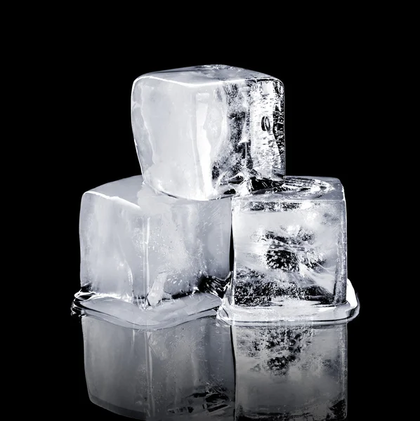 Três cubos de gelo isolados sobre um fundo preto — Fotografia de Stock