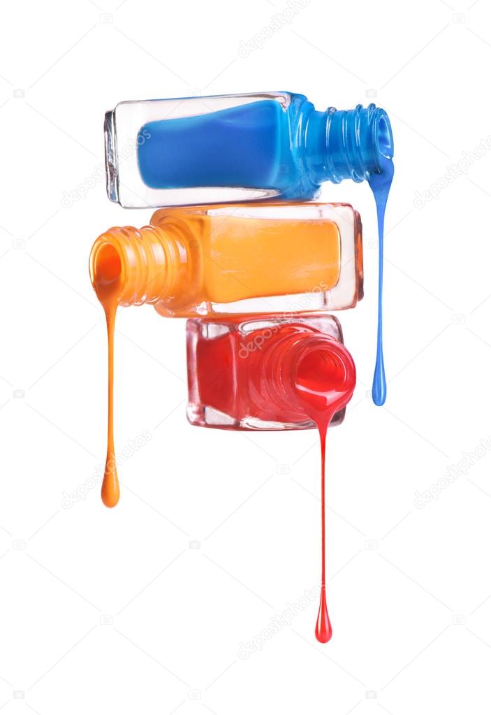 Bottles with spilled nail polish over white background