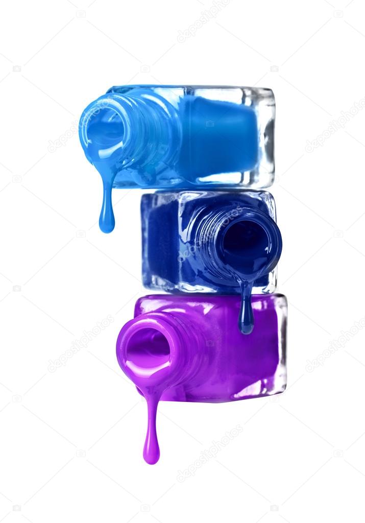 Bottles with spilled nail polish over white background