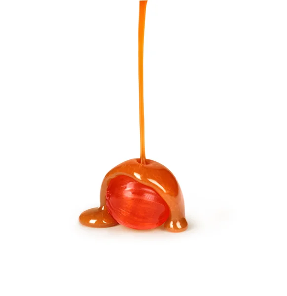 Caramel candies and caramel sauce pouring isolated on a white ba — Stock Photo, Image