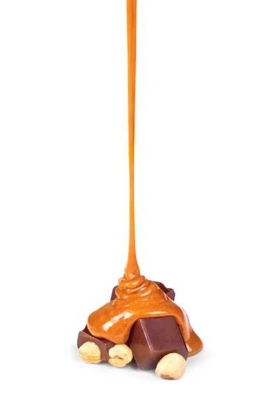 La sauce au caramel sucrée est versée sur une barre de chocolat — Photo