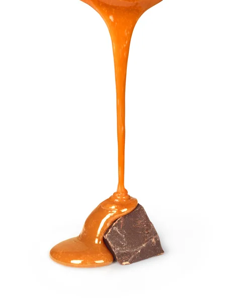 La sauce au caramel sucrée est versée sur une barre de chocolat — Photo