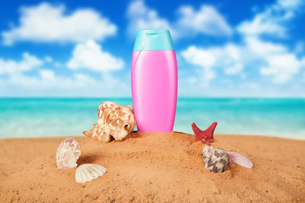 Zonnebrand crème fles op het strand — Stockfoto