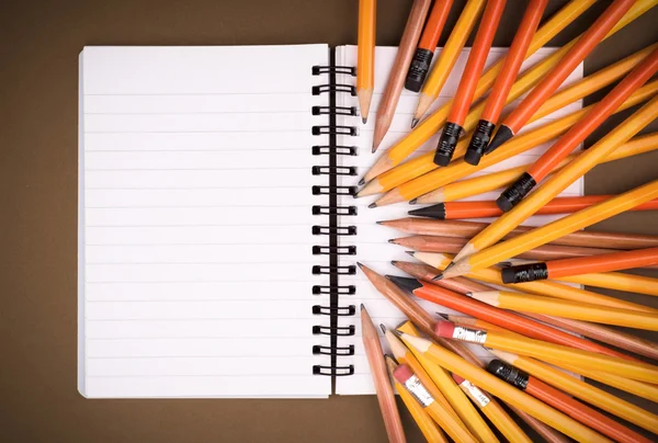 Cuaderno abierto en blanco sobre grunge con pancils — Foto de Stock