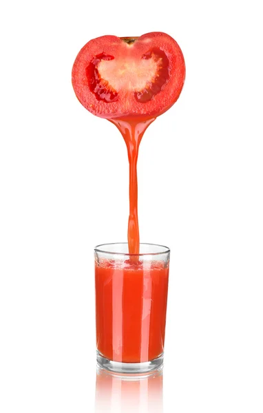 Fresh tomato juice flowing from tomato piece into the glass. Iso — Stock Photo, Image