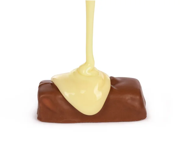 सफेद चॉकलेट सिरप सफेद पीठ पर अलग चॉकलेट पर डाला गया — स्टॉक फ़ोटो, इमेज