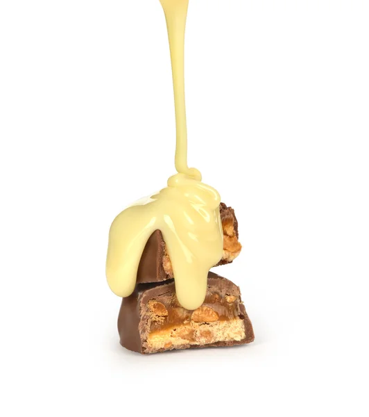 Sweet milk sauce is poured on a chocolate bar — Stock Photo, Image