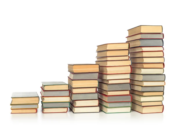 Scale dalle pile di libri su uno sfondo bianco isolato — Foto Stock