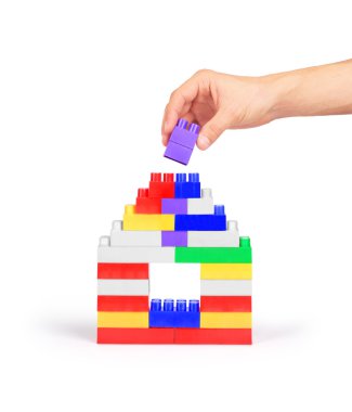 Beyaz bir arka plan üzerinde blokların bir ev inşa el