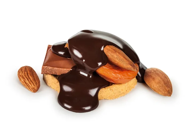Melted chocolate poured on biscuits and dried fruit and nuts iso — Stock Photo, Image
