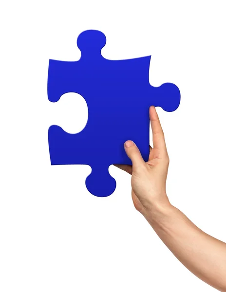 Mano che tiene pezzo puzzle su sfondo bianco isolato — Foto Stock