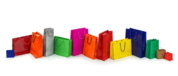 Fila de coloridas bolsas de compras aisladas sobre fondo blanco —  Fotos de Stock
