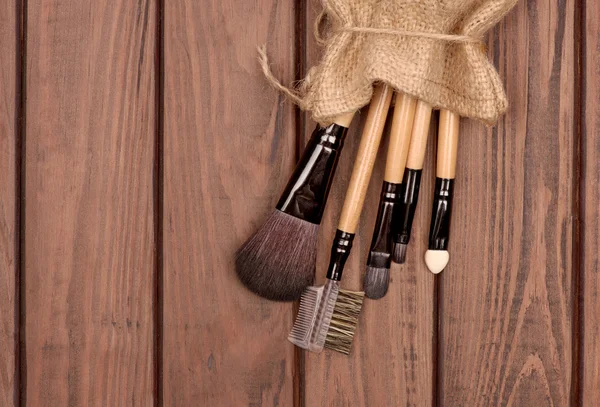 Set of brushes for makeup scattered chaotically on wooden backgr — Stock Photo, Image