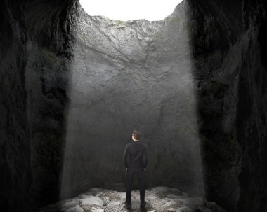 Man stands under the light at the bottom of the deep cave and looks up, 3d illustration