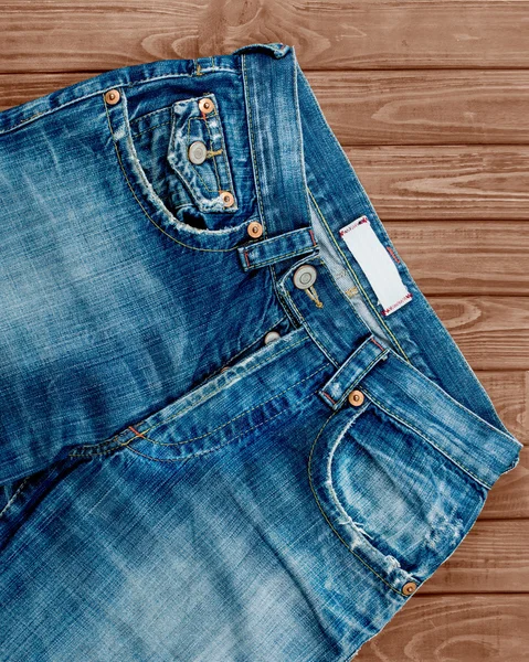 Calça jeans azul no fundo de madeira — Fotografia de Stock