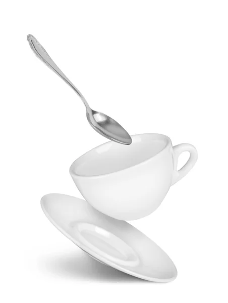 Tasse tombante avec soucoupe et cuillère sur fond blanc isolé — Photo