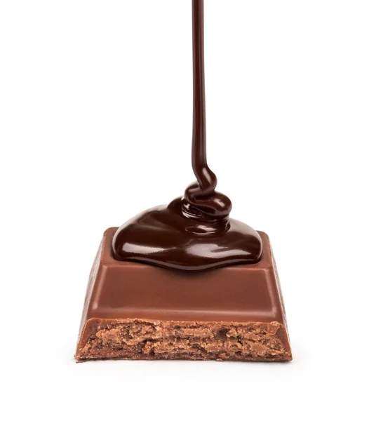 Chocolate escuro é derramado em um pedaço de chocolate com leite com um f — Fotografia de Stock