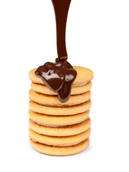 Chocolate derretido vertiendo sobre galletas aisladas sobre fondo blanco — Foto de Stock