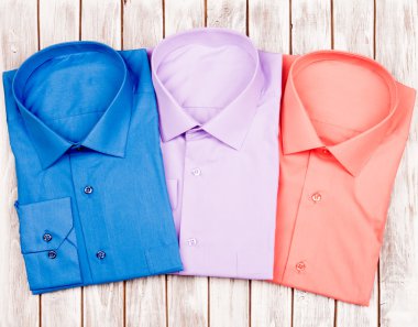 ahşap zemin üzerinde üç t-shirt