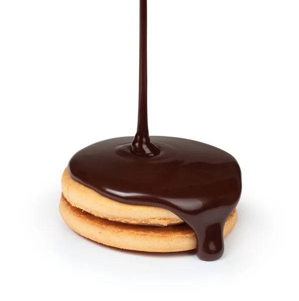 Em biscoitos derramando fluxo de chocolate em um fundo branco — Fotografia de Stock