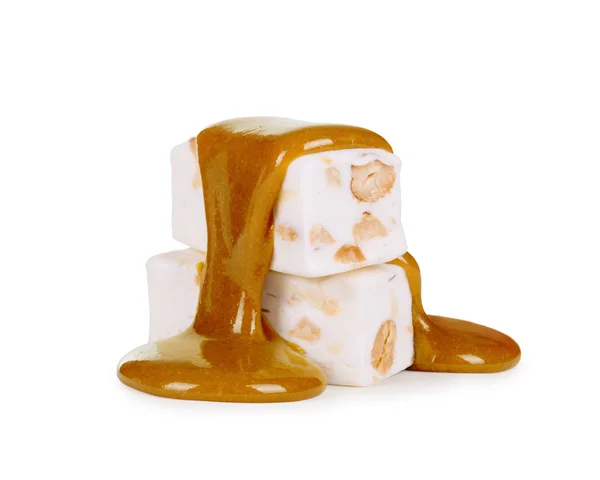 Caramel liquide descend les bonbons nougat et les noix sur un ba blanc — Photo