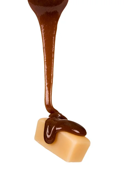 Sciroppo di cioccolato viene versato su un pezzo di caramella — Foto Stock