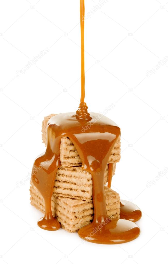 Sweet caramel sauce is poured on a waffle cookies